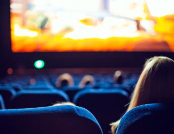 woman sitting in darkened theater watching a movie