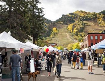 people walking at an outdoor farmers market