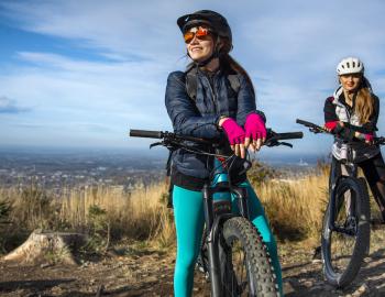 two women on mountain bikes at the top of a mountain