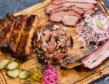 platter of BBQ meats, slaw, onions and pickles 