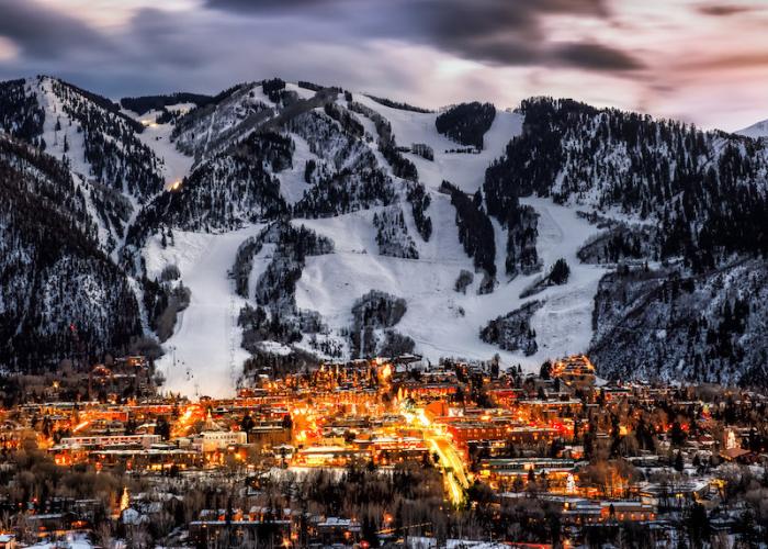 Aspen at dusk in winter with snow covered slopes in the background