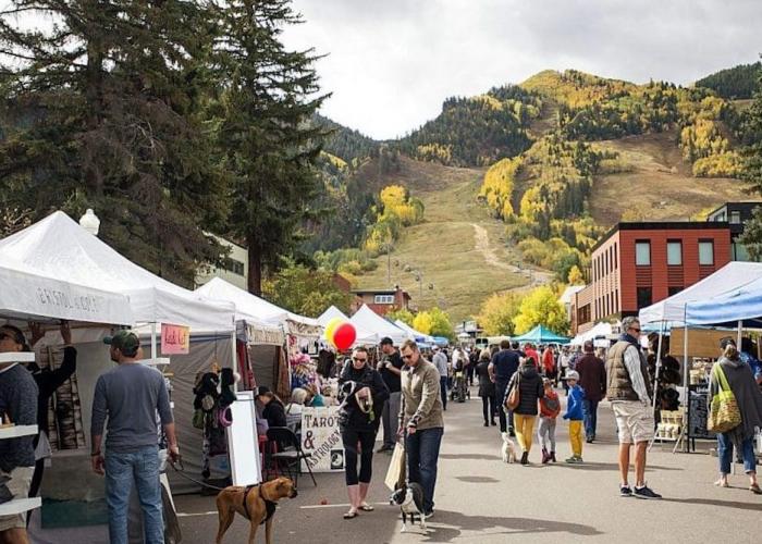 people walking at an outdoor farmers market