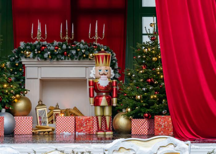 Large nutcracker doll standing beside presents