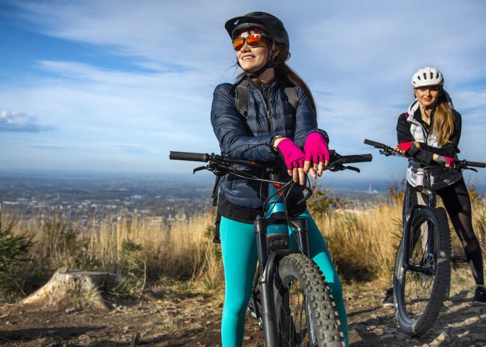 two women on mountain bikes at the top of a mountain
