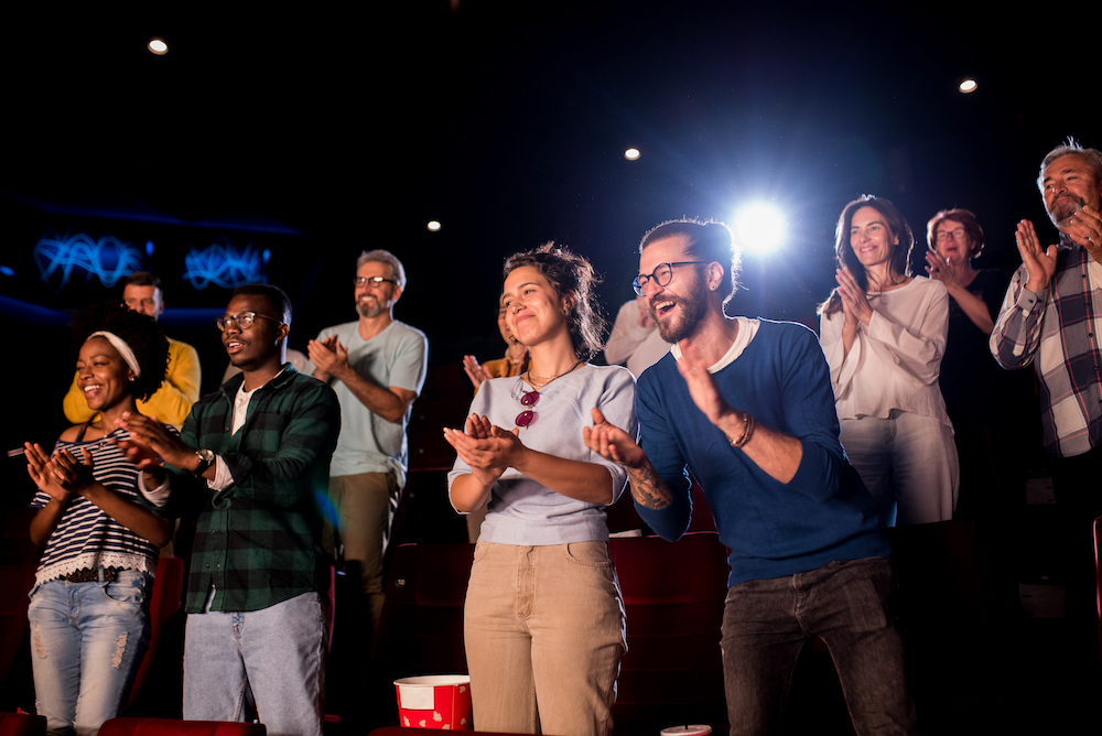 people clapping in a movie theater after a film