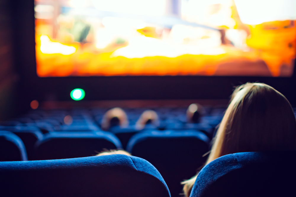 woman sitting in darkened theater watching a movie